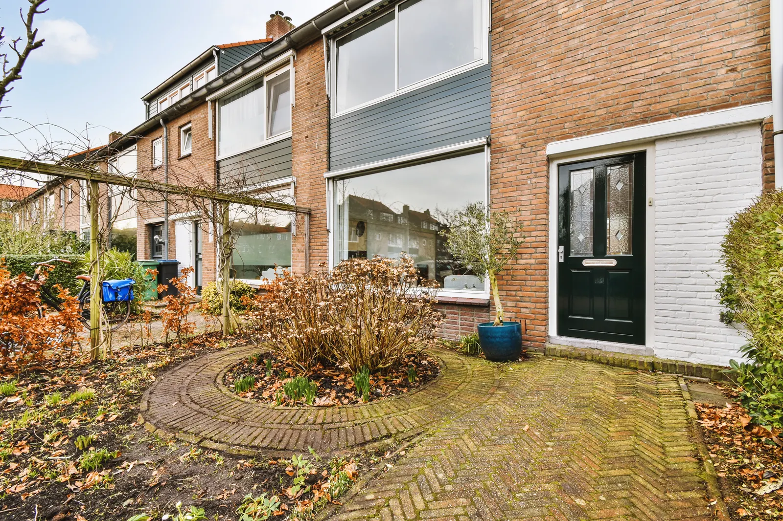 De gevel van een bakstenen woning met kozijnen