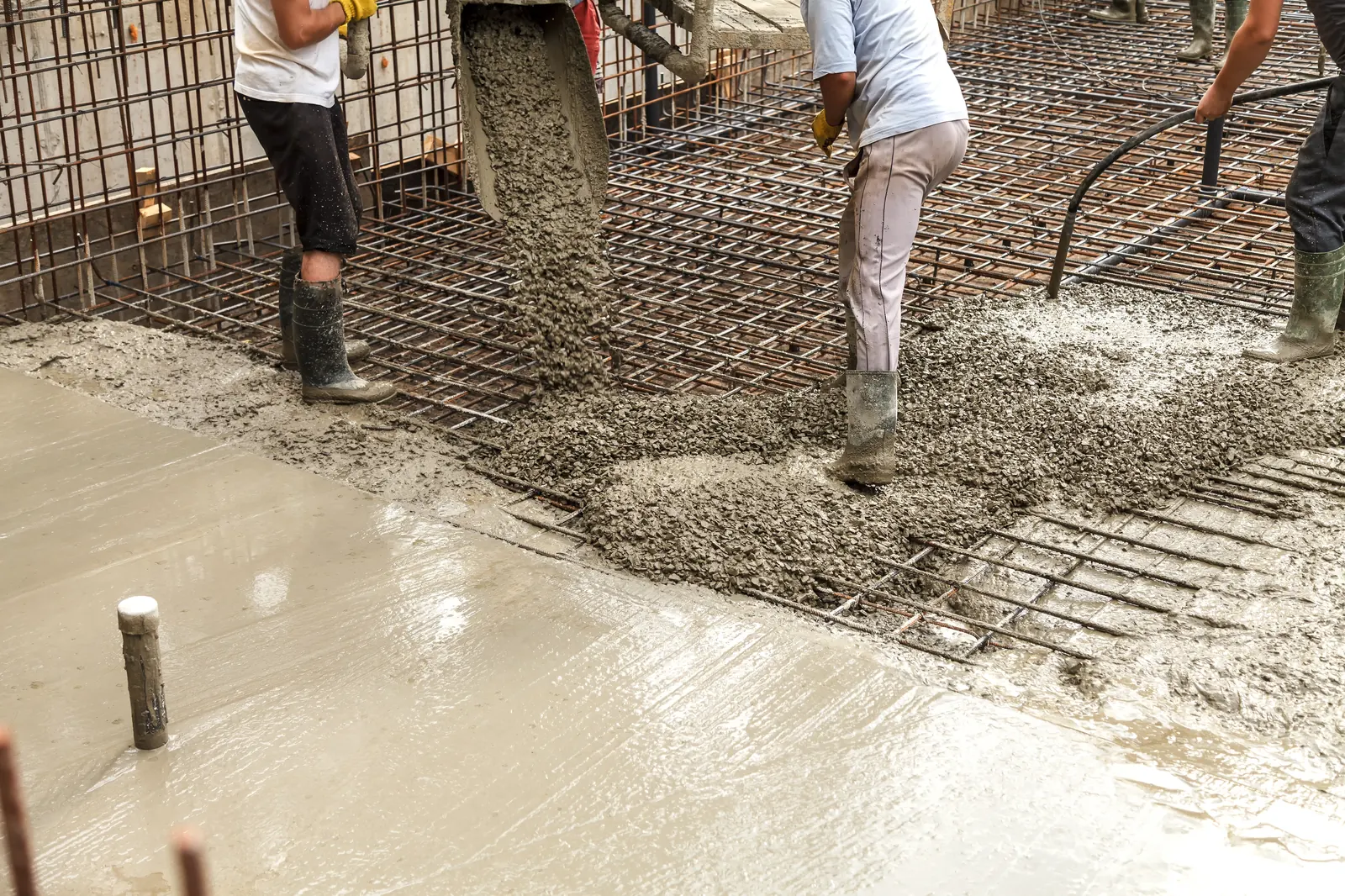 Beton wordt in de bekisting van een fundering gestort
