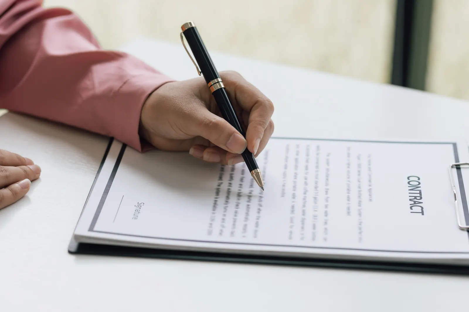 Een koopakte wordt ondertekend, met een huissleutel ernaast