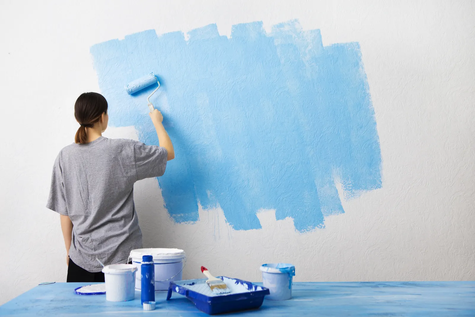 Iemand verft een binnenmuur met een verfroller