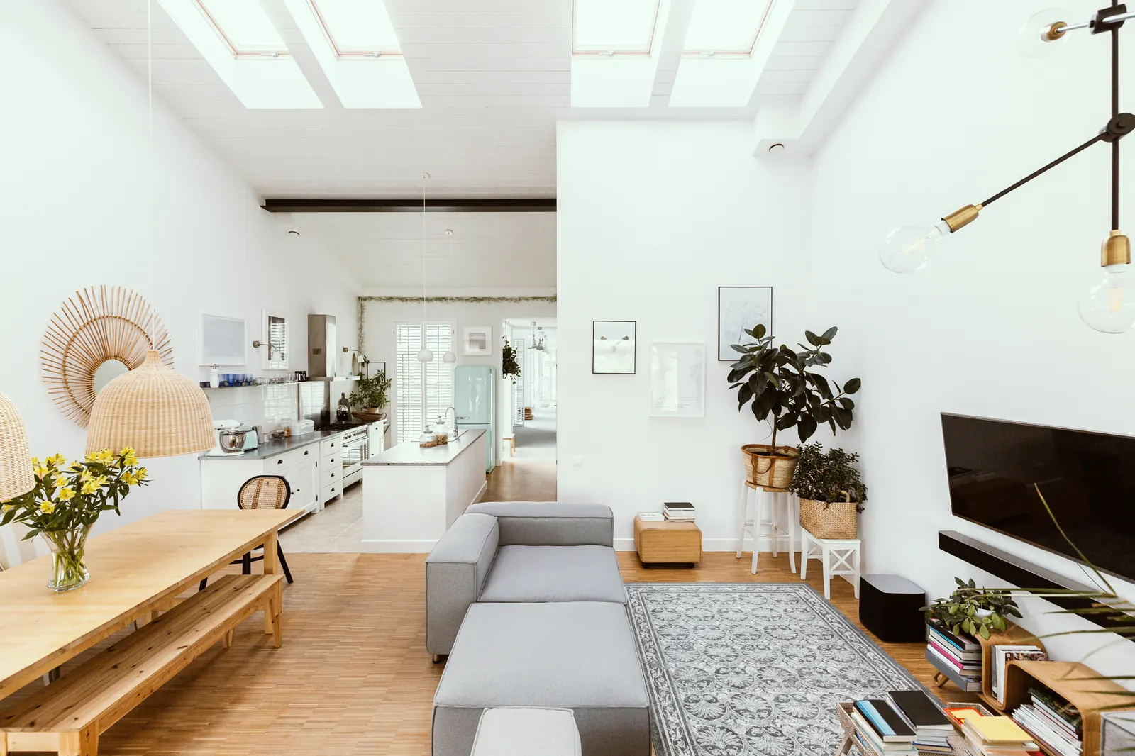 Een lichte woonkamer met bank en grote ramen
