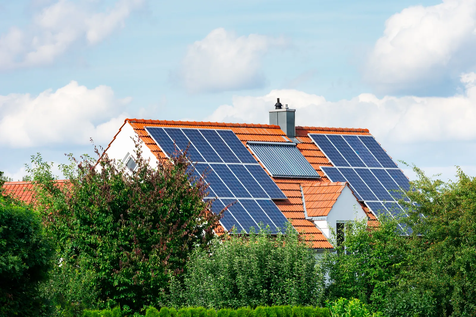 Een woning met zonnepanelen en een zonneboiler op het dak